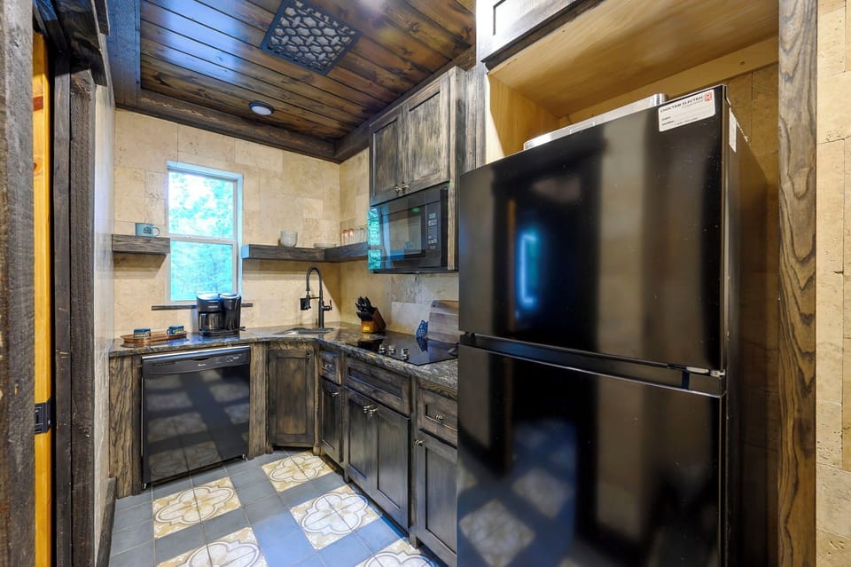 Cook up your favorite meals in this fully equipped kitchen featuring dark wood cabinetry, modern appliances, and a cozy rustic charm that makes your stay feel like home.