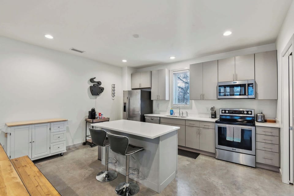 The sleek, open kitchen offers ample space & every home comfort