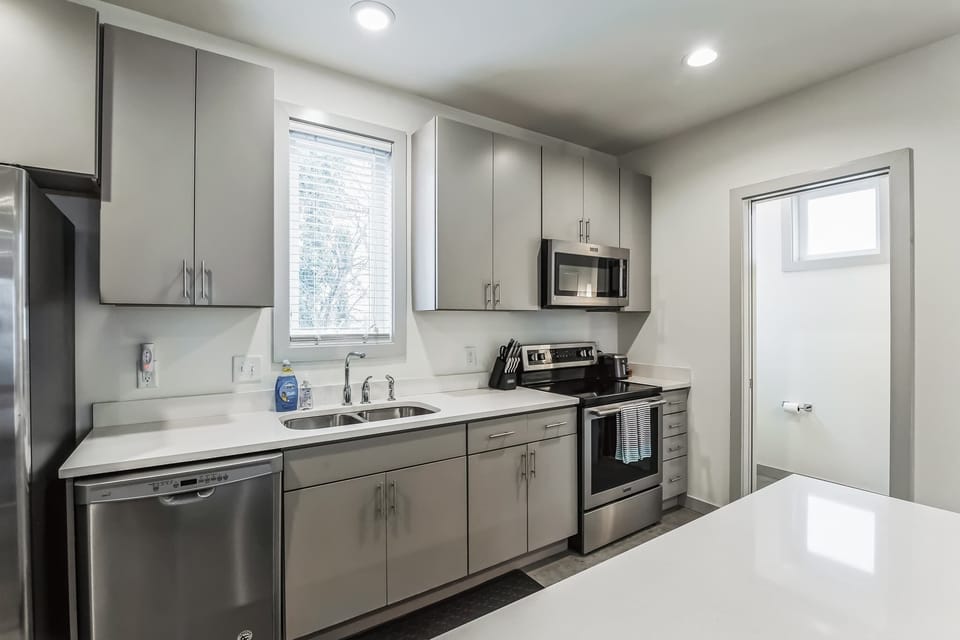 The sleek, open kitchen offers ample space & every home comfort