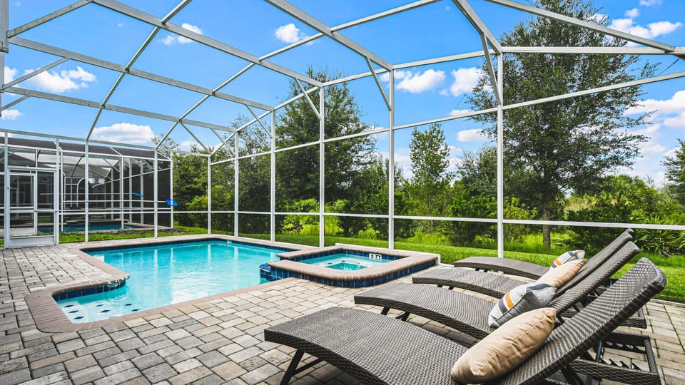 Relax in the private screened pool and spa with lush views and sunny loungers.