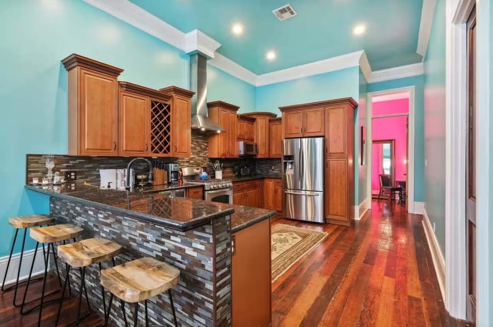 Spacious kitchen featuring a full set of appliances, bar seating at the counter, and all the cookware, dishes, and utensils you could need.