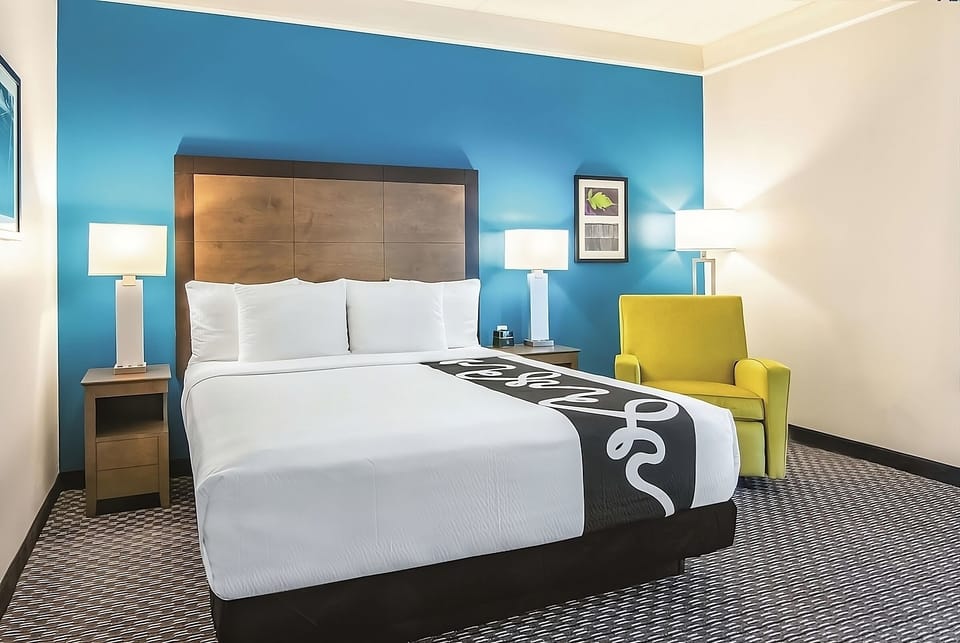 Recharge in a bright room with plush bed and reading chair.