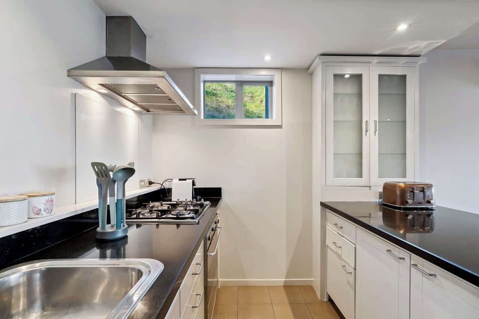 
Modern kitchen with gas stove, stone benchtops, and full cooking amenities.