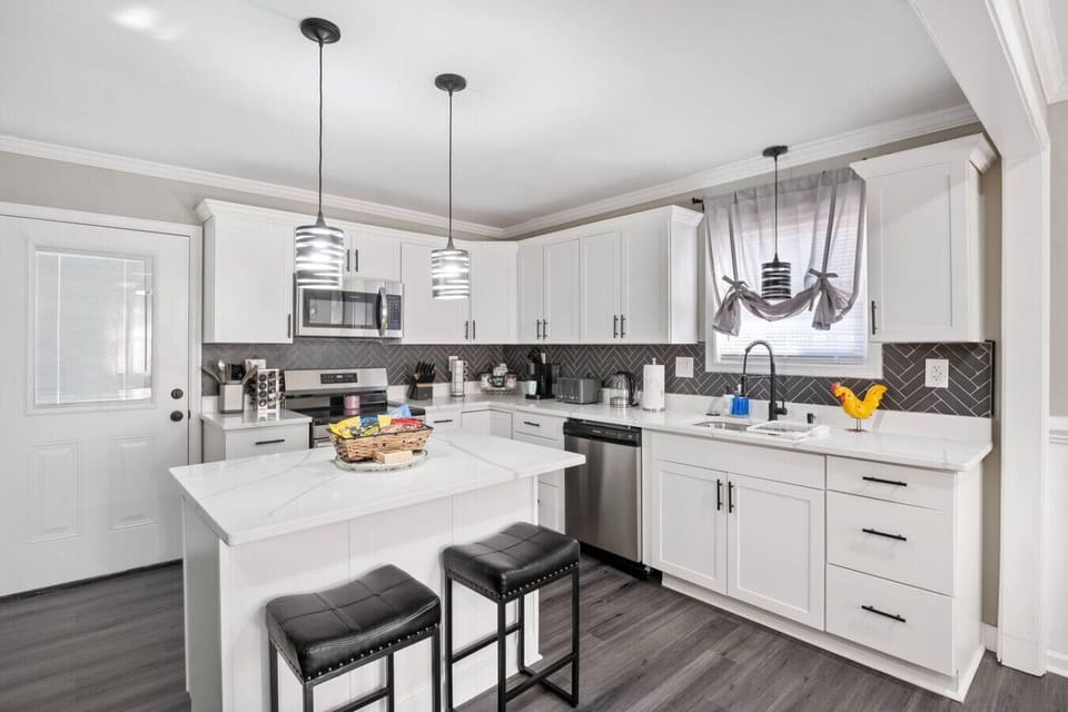 Whip up culinary delights in a fully equipped kitchen- a snack basket too! Enjoy a spacious island and seating for two, a coffee corner, and all the essentials! Direct access to the deck and downstairs area makes this kitchen the heart of the home.