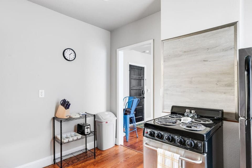 A fully equipped, well-lit space with an oven range, Keurig, dishwasher, and thoughtful touches like a paper towel dispenser. Perfect for whipping up meals or enjoying your morning coffee.