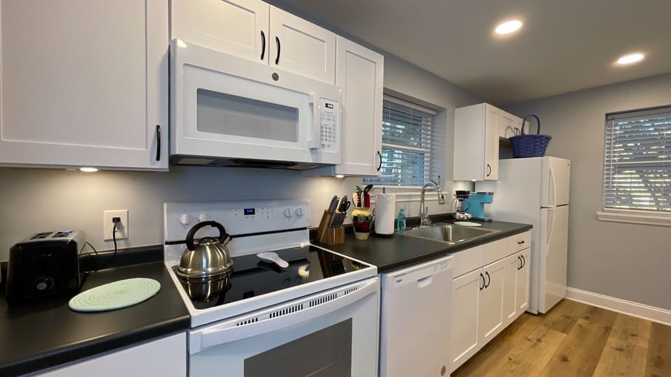 Whip up your favorite meals in this fully equipped, modern kitchen featuring an oven, fridge, and all the essentials!