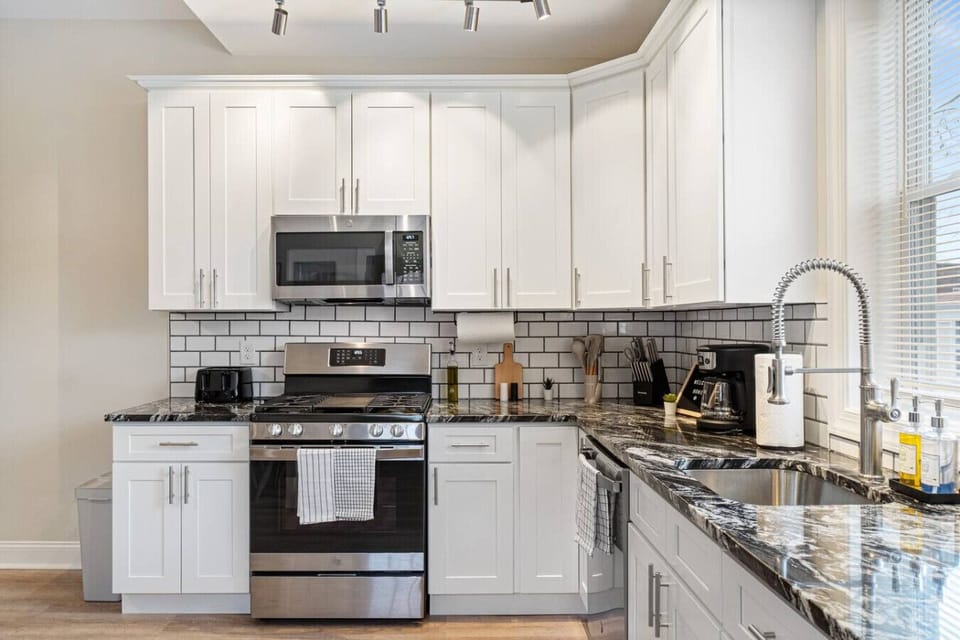 Cook with ease in this well-equipped kitchen featuring stainless steel appliances, ample cabinetry, and a stylish backsplash. Whether you're brewing coffee or preparing a gourmet meal, this space is designed for functionality and style, making every meal