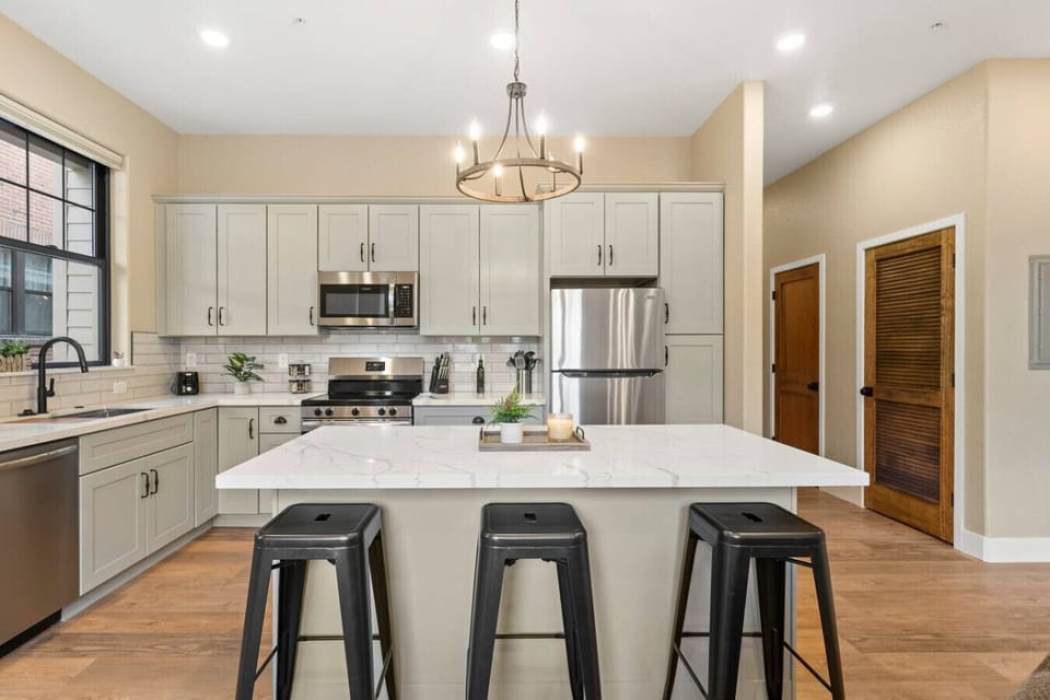 ather around this spacious and elegant kitchen island, complete with sleek finishes, stainless steel appliances, and ample counter space.