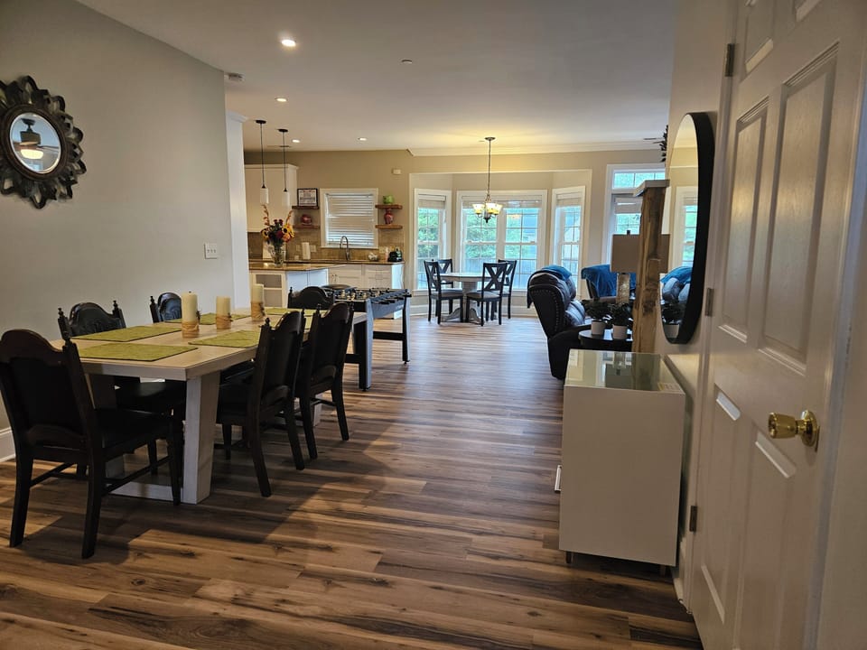 Dining table with comfortable seating, offering a great view of the cozy living room.