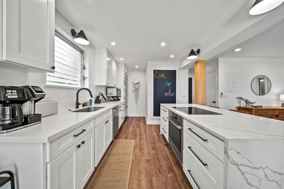 Gourmet kitchen with premium appliances and white cabinetry, creating a bright and inviting space to prepare island-inspired meals.