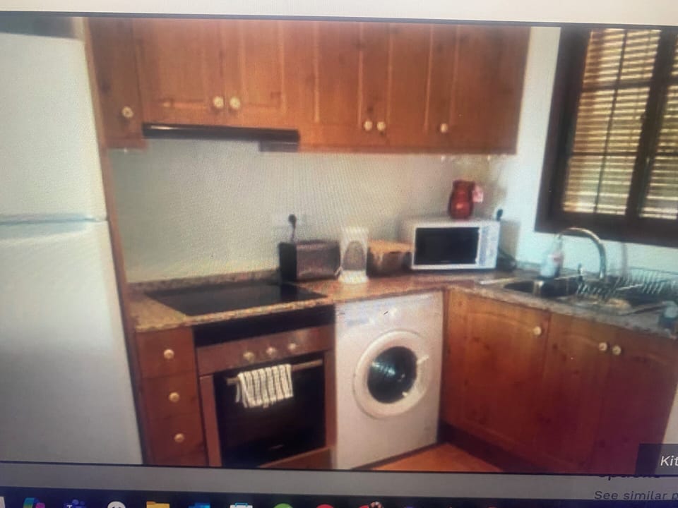 Kitchen with fridge/freezer, ceramic hob, oven, washing machine, microwave