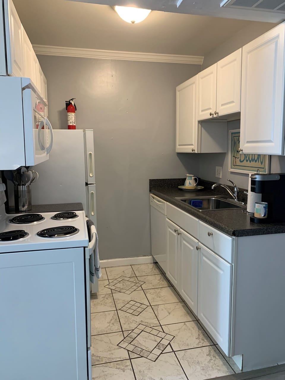 Galley kitchen equipped to meet your eat in needs.  Bring your own coffee pods!