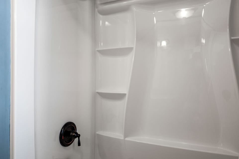 The bathroom has a shower-tub combo.