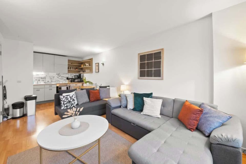 A perfect blend of sophistication and comfort, this living room features soaring ceilings, elegant lighting, and plush seating bathed in natural light. Rich textures, bespoke décor, and warm wood accents create an inviting space ideal for relaxation.