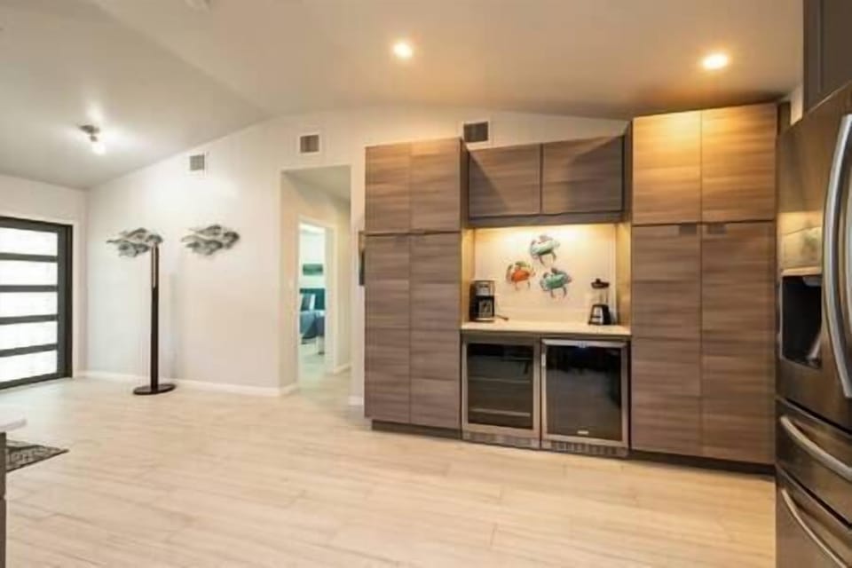 The open concept living leads to the front door and guest wing.