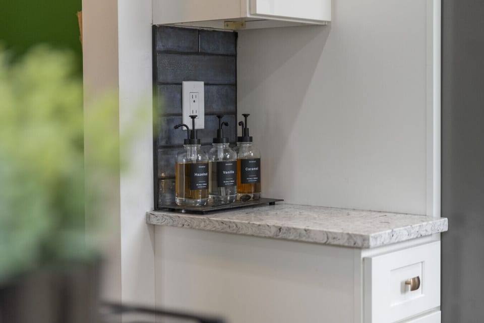 A symphony of style!  The warm wood floors, rich rug, and sleek white cabinets create a sophisticated and inviting space.  Absolutely love it!
