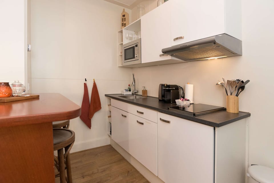 Prepare meals easily in the modern kitchen, complete with a microwave, oven, fridge, dishwasher, and induction hob, plus a cozy bar with four stools.