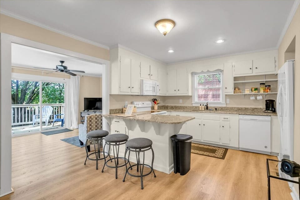 Continuing down the hall into the kitchen, equipped with an electric stove, microwave, coffee maker, and fridge, perfect for all your cooking and brewing needs.