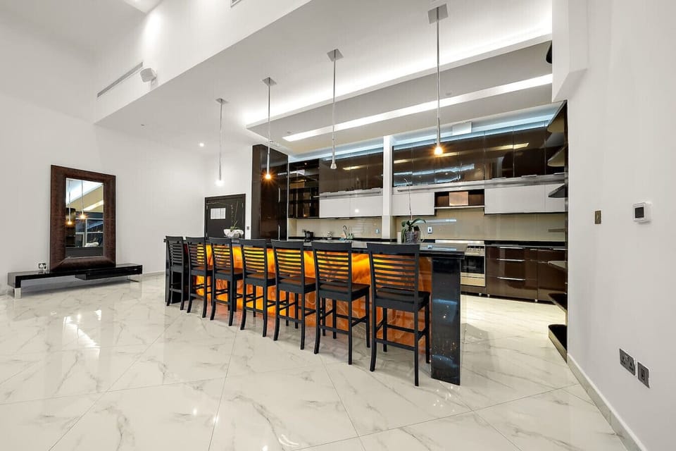 Modern Kitchen: Cook up a feast in this sleek space with stunning marble floors and chic bar seating!