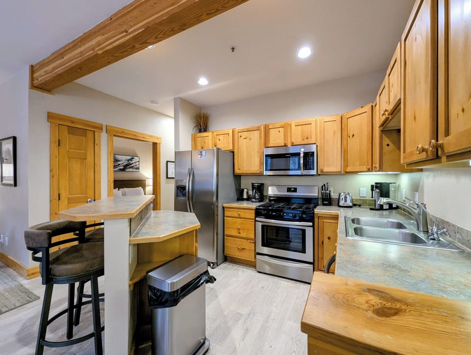 Gather around your fully equipped kitchen featuring warm wood cabinets, granite counters, and modern appliances for memorable meal prep.