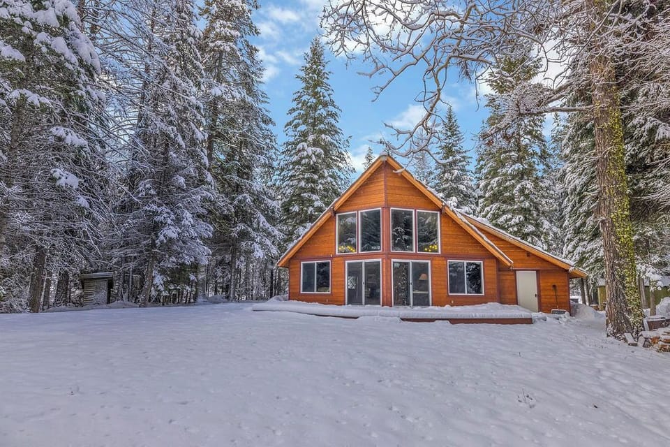 Charming cabin in a snowy forest with stunning views and a cozy interior.