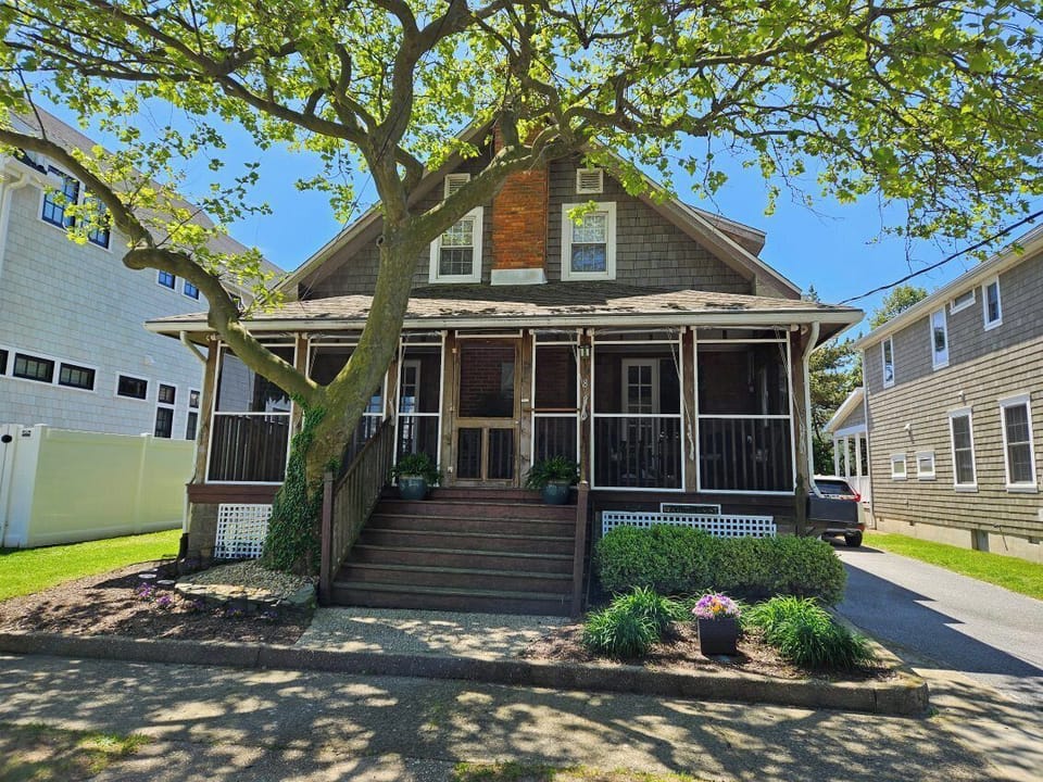 Enjoy coastal or lake breezes sitting on the screened front porch of this quintessential beach cottage!