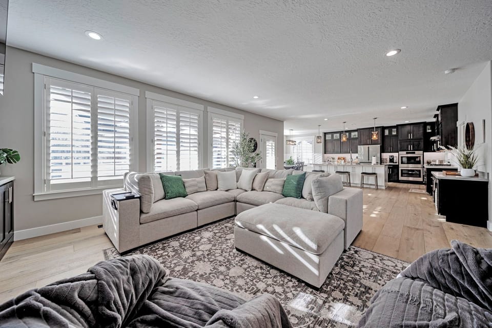 Bright open living space with large sectional and modern chef’s kitchen