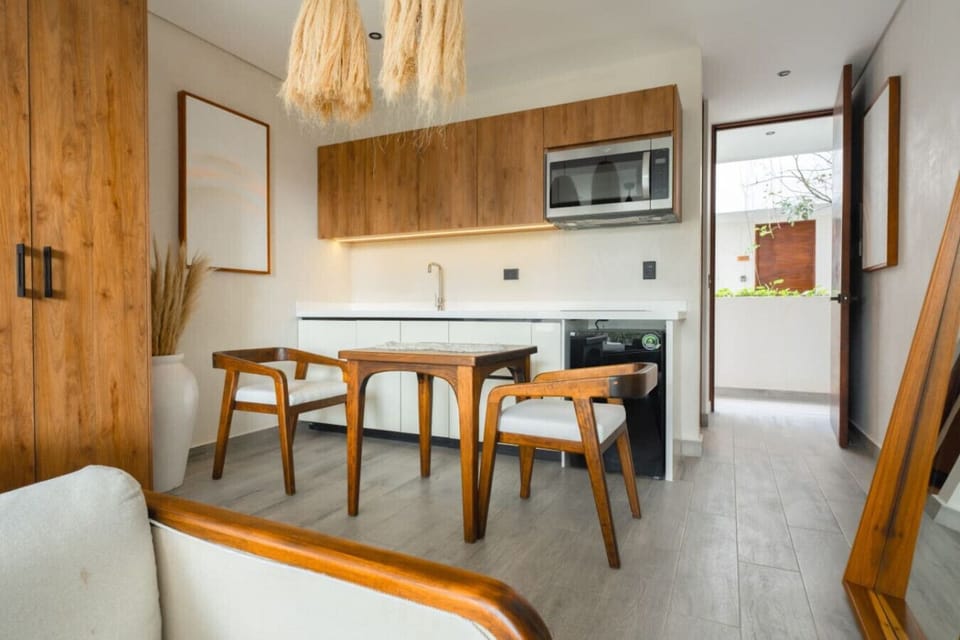 Compact kitchen with dining table and wood details.