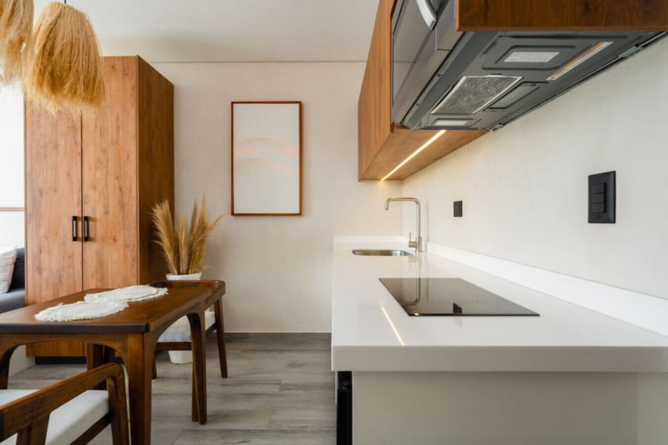 Compact kitchen with wood accents and dining table.