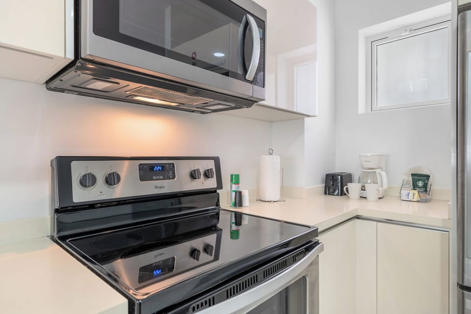 Chic kitchen with a spacious island and bar stools, ideal for casual dining or morning coffee - Stainless steel appliances and elegant finishes create a sleek, modern look - Functional and stylish space designed for both cooking and socializing