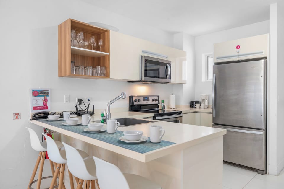 Modern kitchen with sleek cabinetry, stainless steel appliances & a functional layout for effortless cooking - Equipped with a microwave, oven & dishwasher, making meal prep & cleanup easy - Bright & open space designed for convenience & style