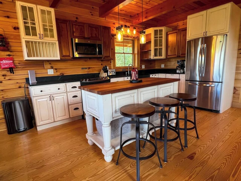 Chef's kitchen with stainless steel fridge/freezer, electric stove and oven, dishwasher, microwave, toaster oven, blender, coffee bar and chef's knives.