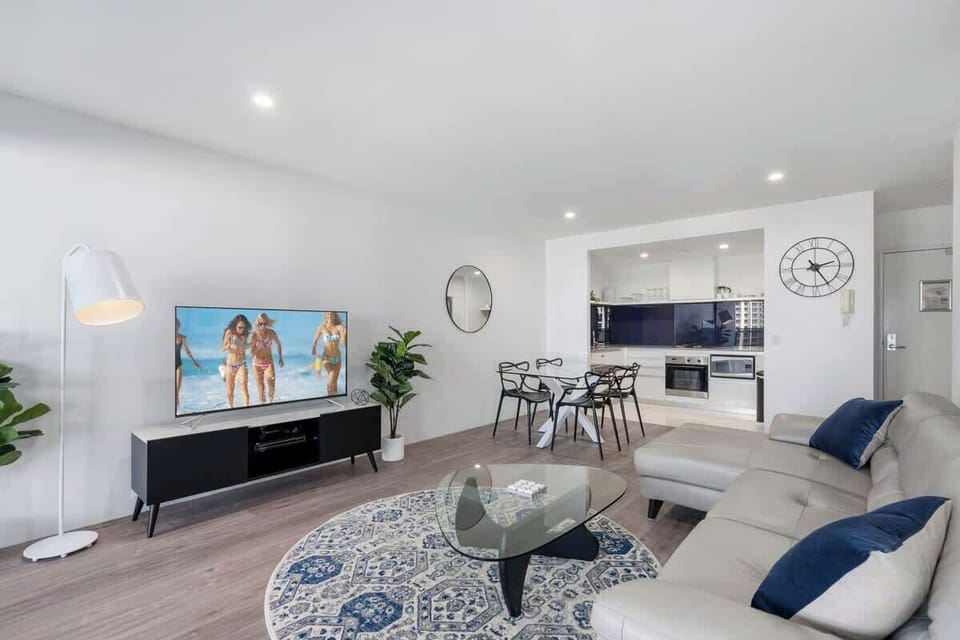 Open plan living/dining with large sofa and flatscreen TV. 