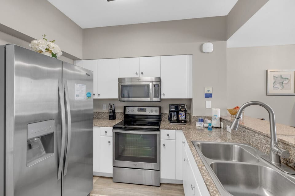 Fully equipped kitchen featuring stainless steel appliances, granite countertops, and all the essentials for a convenient stay.