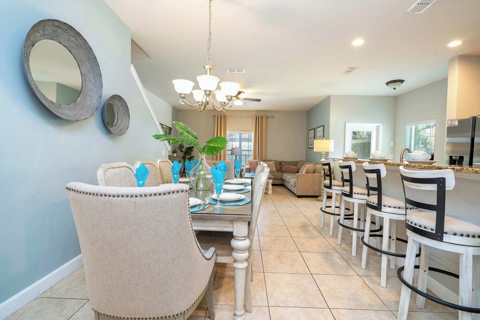 This spacious open-plan dining and kitchen area is perfect for entertaining-enjoy meals together at the elegant table or breakfast bar in a setting filled with light and style.