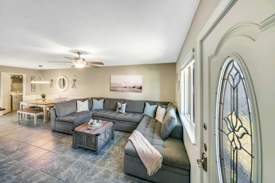 The living room offers ample, comfortable seating and a large flat screen television.