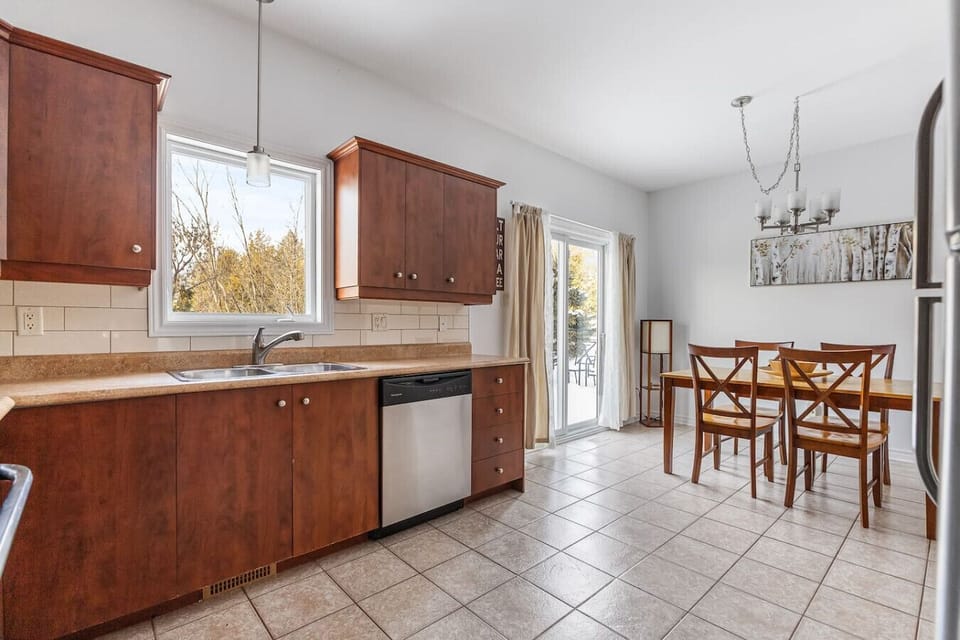 Eat-in kitchen with stainless steel dishwasher and direct access to the patio.