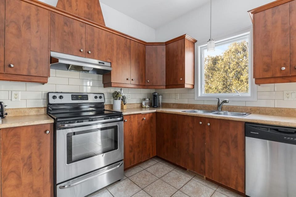 Bright kitchen with stainless steel appliances and ample cabinet storage.