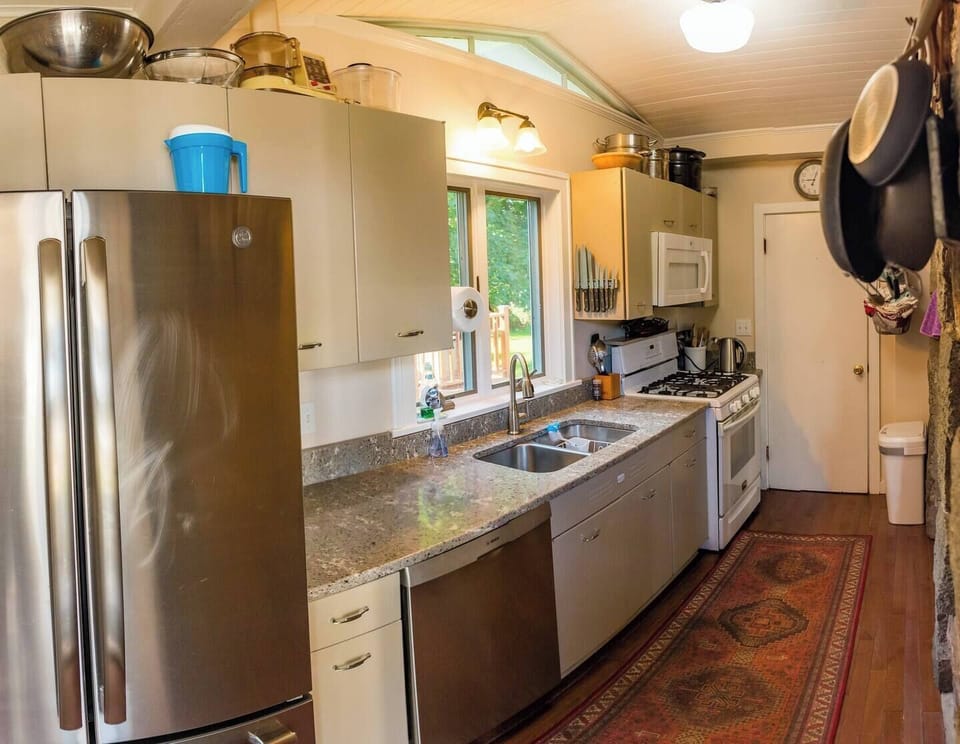 A charming galley kitchen and an extra bathroom have been added to the outside