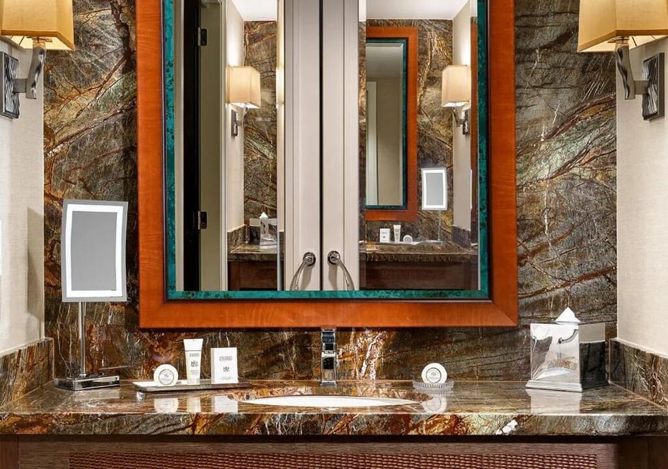 Start mornings at the stone vanity with bright mirror lighting.