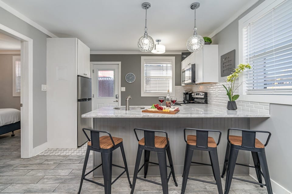 Bright and modern, this kitchen shines with a sleek marble countertop, stylish lighting, and everything you need for a perfect meal or casual gathering.