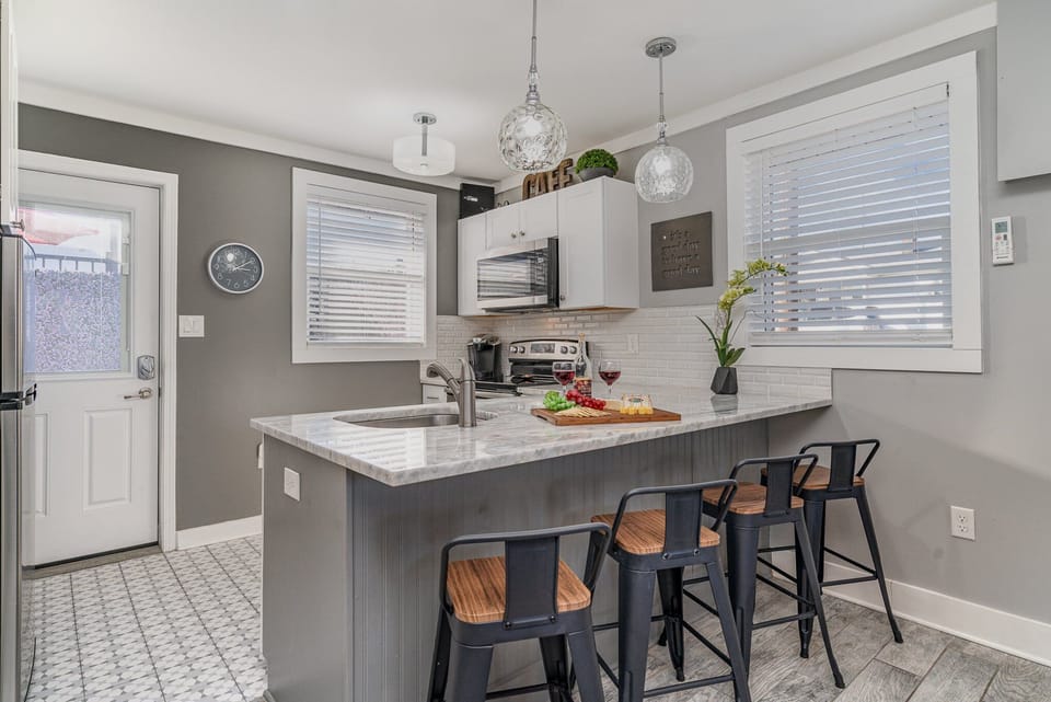 Bright and modern, this kitchen shines with a sleek marble countertop, stylish lighting, and everything you need for a perfect meal or casual gathering.