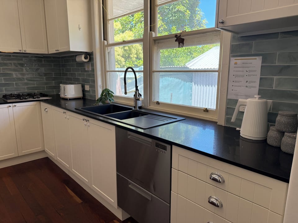 Your culinary hub awaits! This kitchen offers all the essentials: a spacious sink, dishwasher, toaster, kettle, and ample prep areas, making meal times simple and enjoyable.