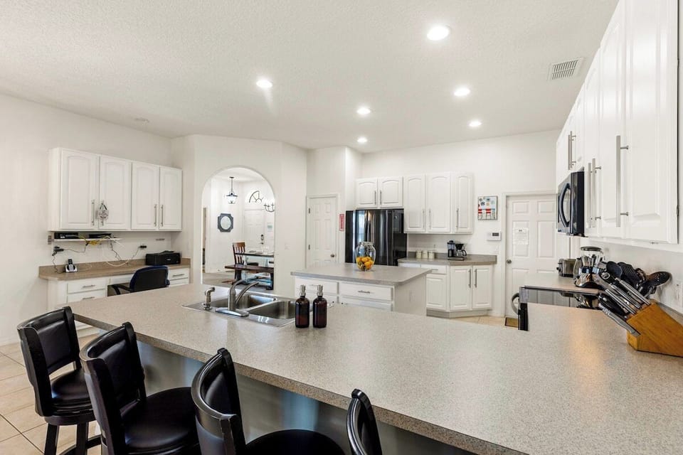 Open concept kitchen with modern appliances and breakfast bar seating for 4