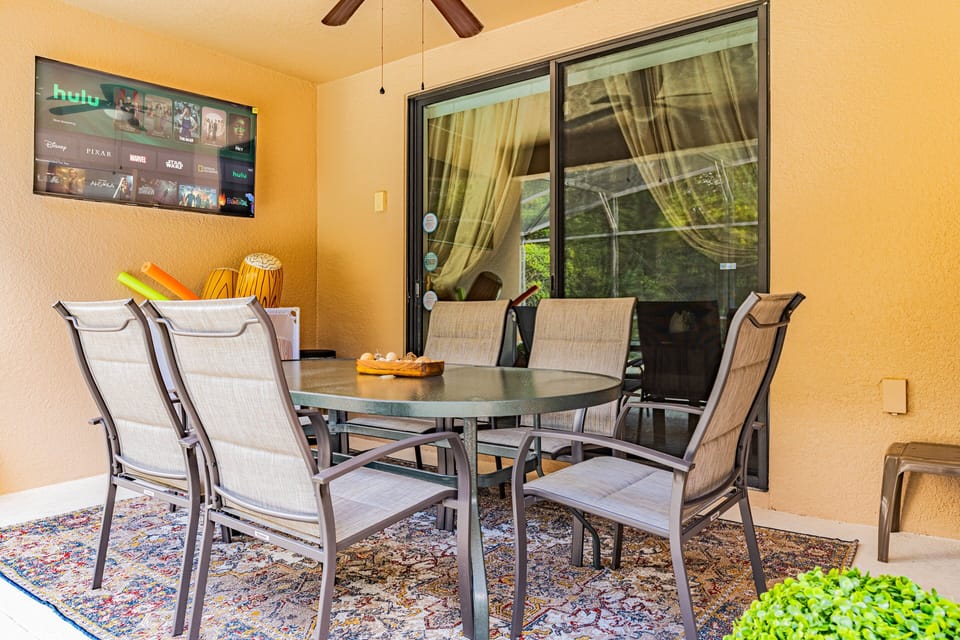 Share meals and make memories on the covered lanai, complete with a dining table, ceiling fan, and TV overlooking the pool.