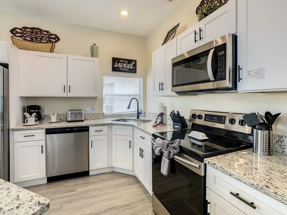 Prepare meals in a stylish and fully equipped kitchen featuring granite countertops and sleek stainless steel appliances. Located near Disney, this Orlando vacation home makes dining-in a delight for guests and families alike.