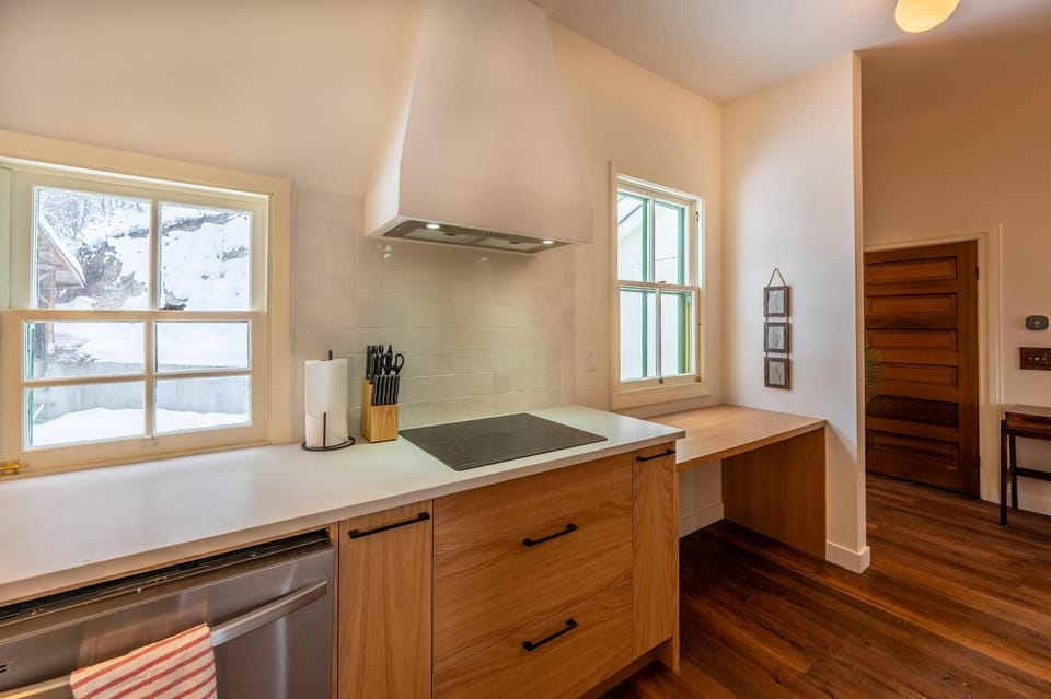 Practical and inviting, the kitchen features warm wood cabinetry and a stovetop for easy meal prep.