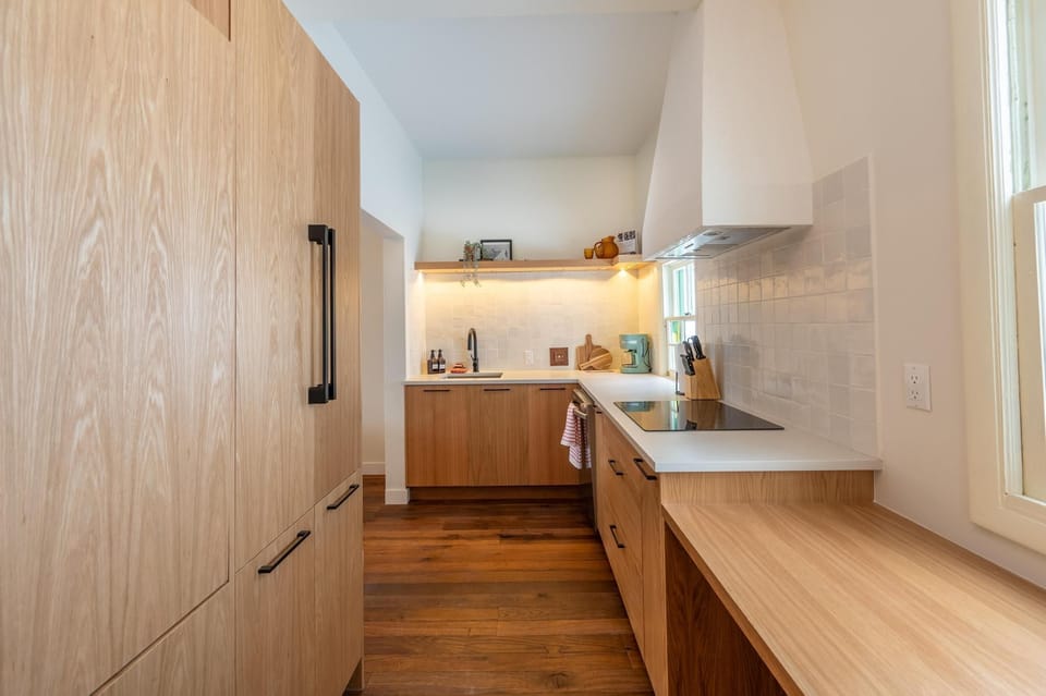 Modern kitchen featuring warm wood cabinetry, ample counter space, and a functional stovetop for easy meal prep.
