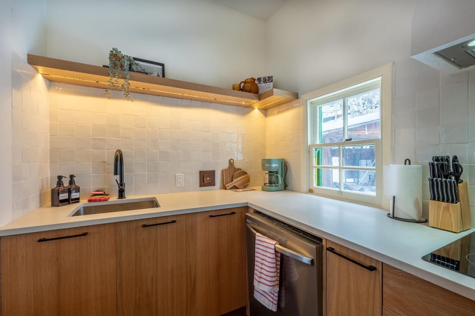 Fully equipped kitchen with modern cabinetry, sleek countertops, and all essentials for preparing meals (stovetop included, no oven).