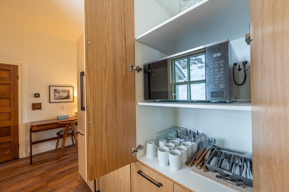 Open shelving in the kitchen showcasing thoughtfully arranged dishes, blending practicality with rustic aesthetics.